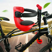 Red child bike seat and handlebar attachment on a bicycle with a scenic background.