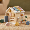 Wooden toy house with colorful beads and shape sorter on a textured surface
