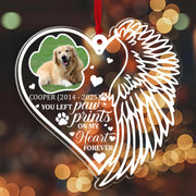 Heart-shaped ornament with a dog's photo, angel wings, and text on a blurred background